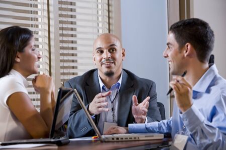 Three office colleagues having discussion at deskの写真素材