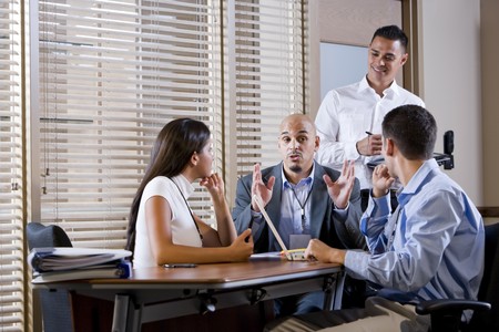 Hispanic business manager meeting with office workers, giving directionsの写真素材