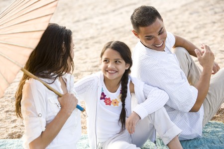 High angle view of happy Hispanic family with 9 year old daughter on beachの写真素材