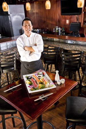 Chef in Japanese restaurant with sushi platterの写真素材