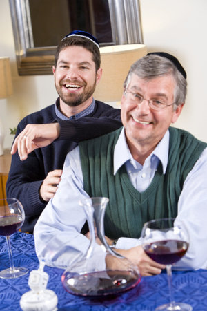 Senior Jewish man and adult son celebrating Hanukkah