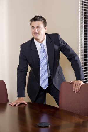 Portrait of confident businessman wearing suit in boardroomの写真素材