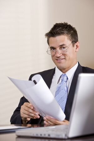 Close up of businessman with laptop working in boardroomの写真素材