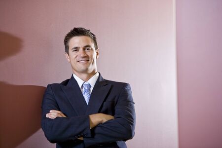Confident businessman wearing suit with arms foldedの写真素材