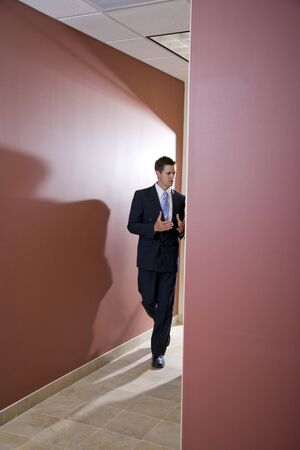 Businessman talking and walking down office corridorの写真素材