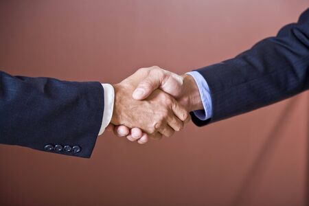 Close up of business handshake, sleaves of men wearing suitsの写真素材