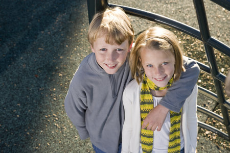 Brother and sister (10 and 11 years) posing together on playground