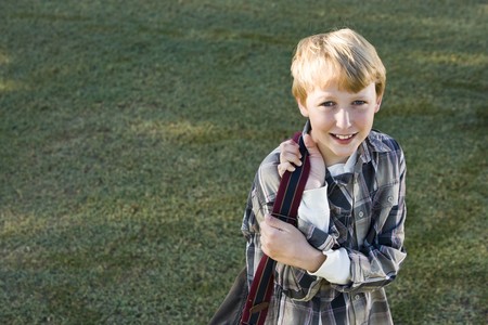Boy (11 years) carrying school backpack, looking at camera smilingの写真素材