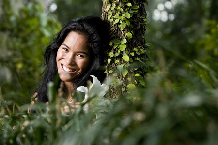 Face of beautiful woman of Pacific Islander ethnicity, 20 years, in the woodsの写真素材