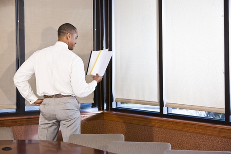 Rear view of African American office worker reading reportの写真素材