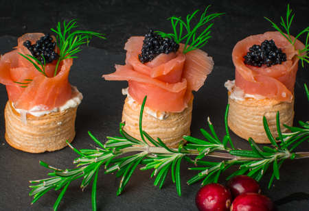 smoked salmon canape on black backgroundの写真素材