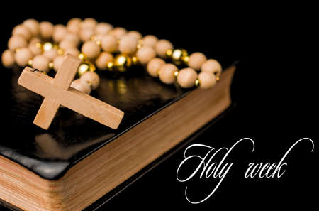 Closeup of wooden Christian cross on bible and prayer beads on black.Church utensils.の写真素材