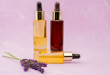lavender and essential oil in little bottle on pink backgroundの写真素材