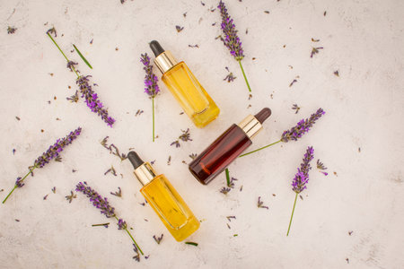 lavender and essential oil in little bottle on pink background