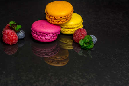 colorful biscuits macaroons on black   backgroundの写真素材