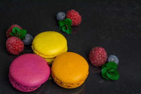 colorful biscuits macaroons on black   backgroundの写真素材