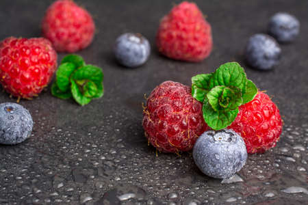 fresh raspberry blueberry with mint on black backgroundの写真素材