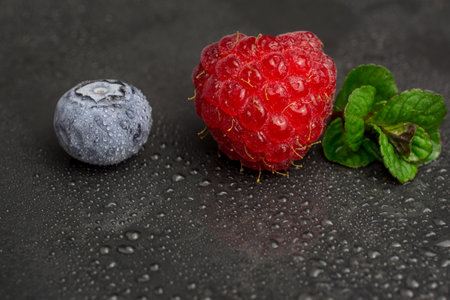 fresh raspberry blueberry with mint on black backgroundの写真素材