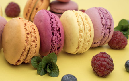 colorful background with biscuits macaroons and berry