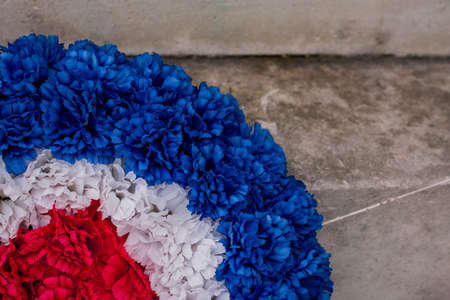 Red poppy wreaths laid at the bottom of a war memorial for Remembrance dayの写真素材