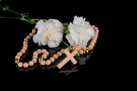 Closeup of wooden Christian cross prayer rosery beads on black.Church utensilsの写真素材