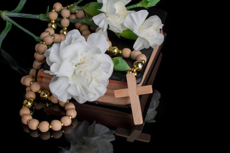 Closeup of wooden Christian cross prayer rosery beads on black.Church utensils