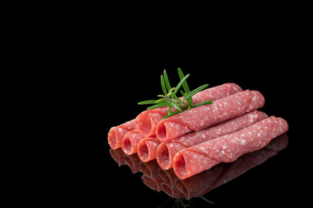 salami slices with herbs on black backgroundの写真素材