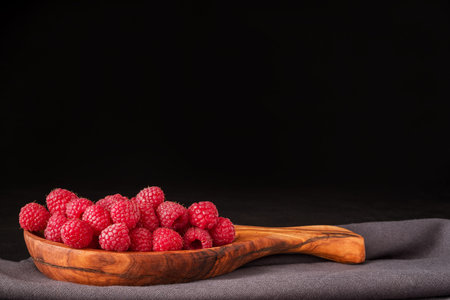 Raspberry berries and fresh mint leaves on dark background