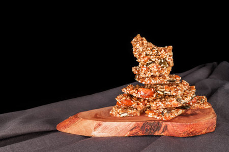 Granola bars with sesame seeds and fresh tomatoes on a black backgroundの写真素材