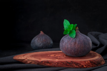 fresh figs on wooden board on dark backgroundの写真素材