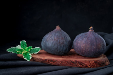 fresh figs on wooden board on dark backgroundの写真素材