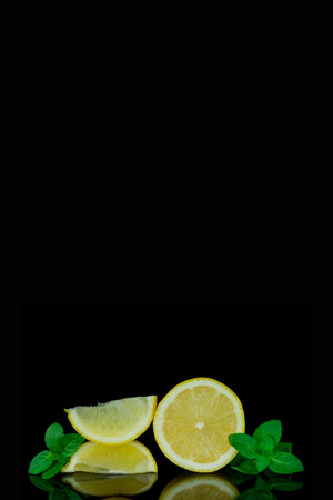 Lemon and mint on a black background. Space for text.の写真素材