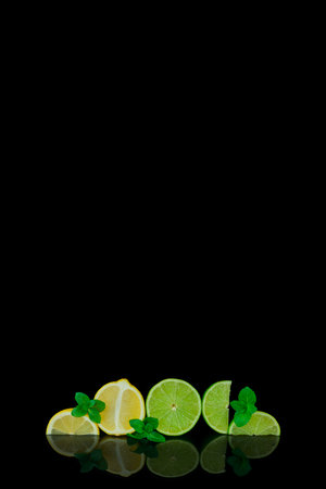 lime slices and mint leaves on a black background with space for textの写真素材