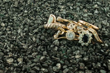 Old and broken scrap gold metal jewellery on black backgroundの写真素材