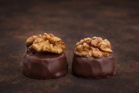 Chocolates with walnuts on a dark background. Selective focus.