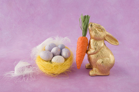 Easter bunny and easter eggs in a nest on a pink background