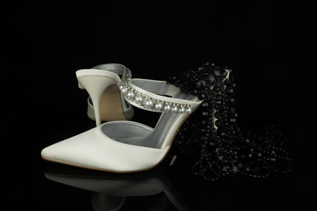 wedding shoes with pearls on a black background close-upの写真素材