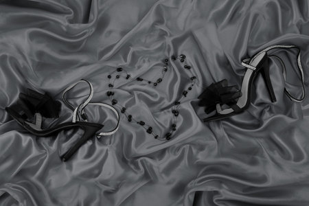 Black women's shoes on a satin background. Black and white photo.の写真素材