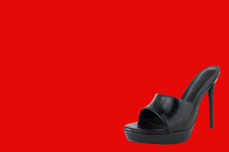 Black women's shoes isolated on a red background with copy space.の写真素材