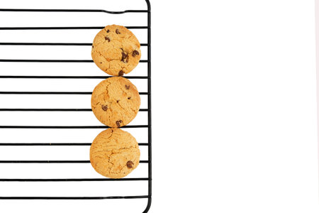 Chocolate chip cookies on a cooling rack isolated on white background.