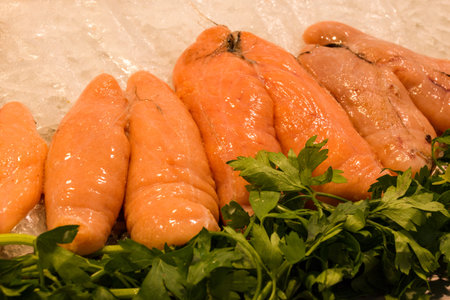 Fresh salmon fillets with parsley on ice in a seafood market