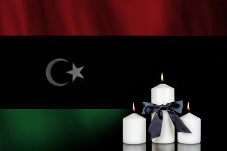 Candles with black ribbon on the Libya flag background. Black candles on the flag background.の写真素材
