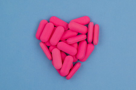 Pink objects in the shape of a heart on a blue backgroundの写真素材