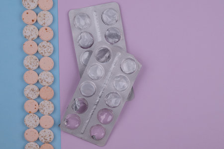 Tablets and pills packed in blisters on a blue background.