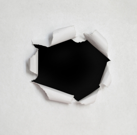 Hole in the paper with torn sides.の写真素材