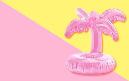 Pink tropical inflatable palm toy on pastel paper background. Trendy minimal summer concept.の写真素材