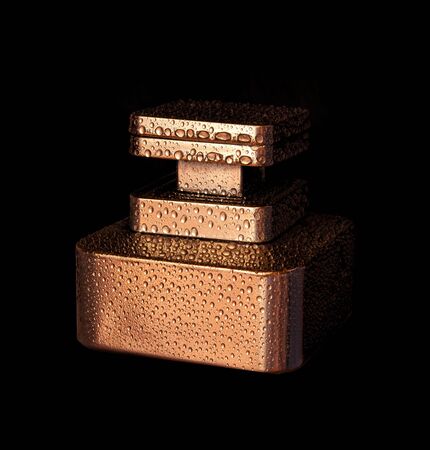 Luxury golden perfume bottle with water drops on black background.の写真素材
