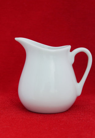 White jug on red clothの写真素材