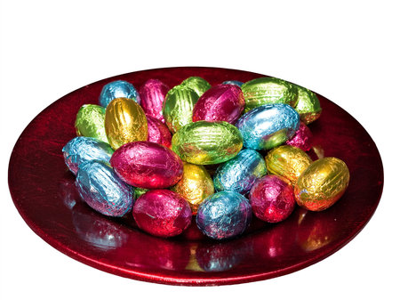 Easter eggs in foil on shiny plate - isolated