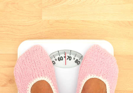 Woman on bathroom scales weight watchingの写真素材